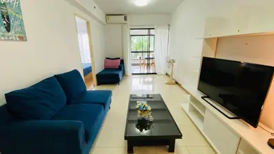 a living room with a blue couch and a tv at Vista Residence Old Town in Phuket Town