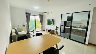 a living room with a wooden table and chairs at Vista Residence Old Town in Phuket Town