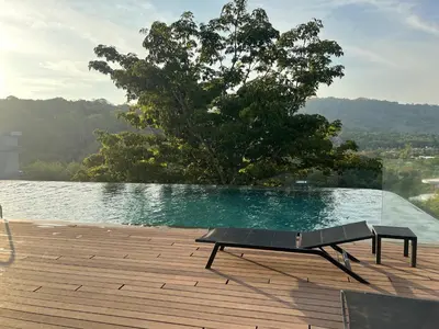 a bench sitting on a deck next to a swimming pool at Studio for rent in Rawai Beach