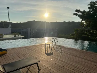 two chairs sitting on a wooden deck near the water at Studio for rent in Rawai Beach
