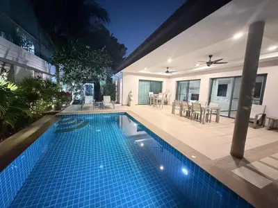 a swimming pool in front of a house at Stunning 3 Bedroom pool villa in Ban Thalat Choeng Thale