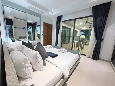 a large white bed in a room with a large window at Stunning 3 Bedroom pool villa in Ban Thalat Choeng Thale
