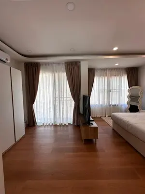 a bedroom with a bed and a couch and windows at Patong Relax Home in Patong Beach
