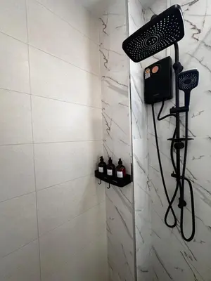 a shower with a shower head in a bathroom at Patong Relax Home in Patong Beach