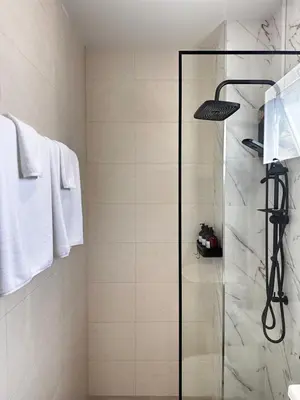 a bathroom with a shower with a glass door at Patong Relax Home in Patong Beach