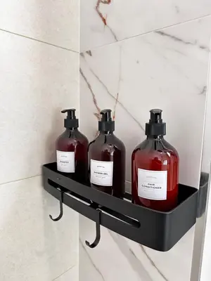 three bottles of soap on a shelf in a bathroom at Patong Relax Home in Patong Beach
