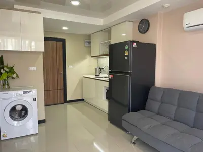 a living room with a couch and a washer and dryer at Rawai Beach Condom in Ban Saiyuan (1)