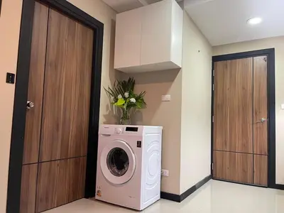 a washer and dryer in a room with a door at Rawai Beach Condom in Ban Saiyuan (1)