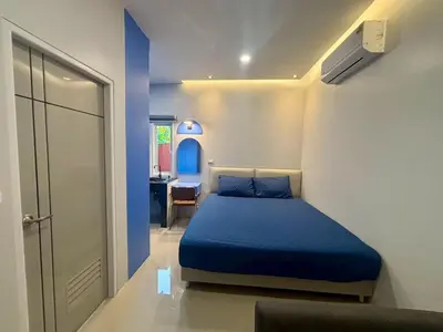 a bedroom with a blue bed and a desk at MSP house bangtao in Ban Thalat Choeng Thale