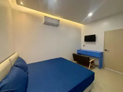 a bedroom with a blue bed and a desk at MSP house bangtao in Ban Thalat Choeng Thale