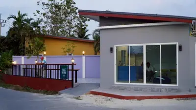 a white house with a large glass door at MSP house bangtao in Ban Thalat Choeng Thale