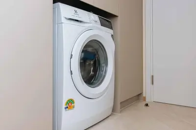 a white washing machine in a room next to a door at C263 Brand New Condo Near Lake & Nai Harn Beach in Rawai Beach