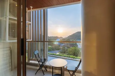 a room with a large window with a table and chairs at C263 Brand New Condo Near Lake & Nai Harn Beach in Rawai Beach