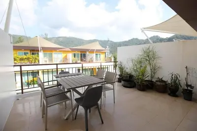 a patio with a table and chairs on a balcony at Modern 3BR Townhouse Kamala in Kamala Beach