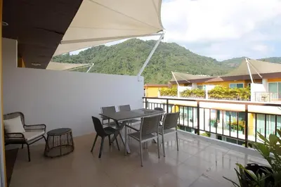 a patio with a table and chairs on a balcony at Modern 3BR Townhouse Kamala in Kamala Beach