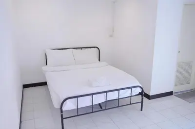 a bed with white sheets and pillows on it at xx GO INN Patong Jangceylon - โกอินน์ ป่าตอง in Patong Beach