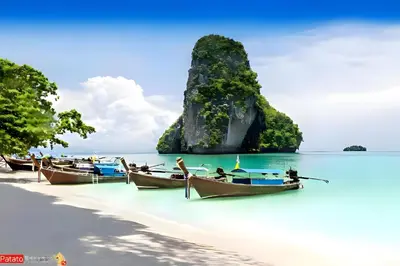 a group of boats on a beach with a small island at xx GO INN Patong Jangceylon - โกอินน์ ป่าตอง in Patong Beach