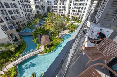 a view of the pool from the balcony of a resort at Vela 1BR Suite — The Title Legendary BangTao in Bang Tao Beach