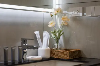a kitchen counter with a sink with flowers in a vase at Vela 1BR Suite — The Title Legendary BangTao in Bang Tao Beach