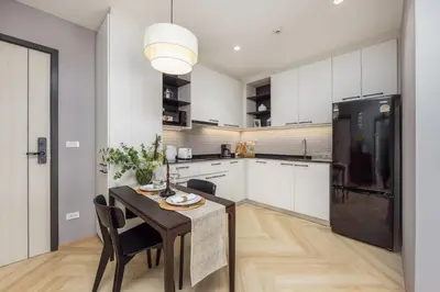 a kitchen with a table and a black refrigerator at Vela 1BR Suite — The Title Legendary BangTao in Bang Tao Beach