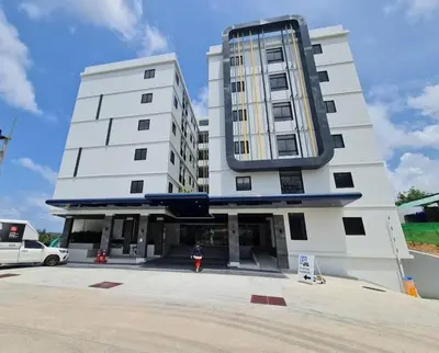 a tall white building with a person standing in front of it at VIP Great Hill Airport in Nai Yang Beach