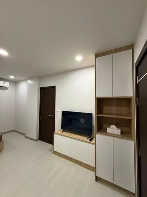a living room with a tv and a book shelf at VIP Great Hill Airport in Nai Yang Beach