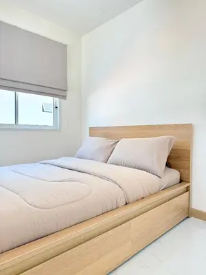 a bed with a wooden frame in a bedroom at Harmony House in Ban Bang Khu