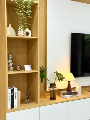 a book shelf with a television and some plants at Harmony House in Ban Bang Khu