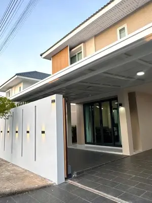 a modern house with a white garage door at Harmony House in Ban Bang Khu