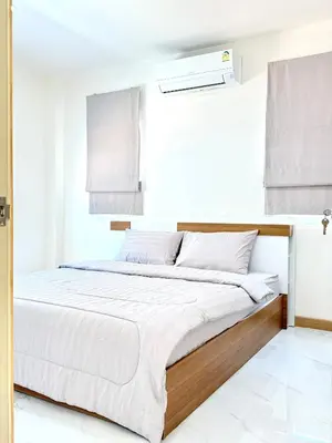 a white bedroom with a bed with white sheets at Harmony House in Ban Bang Khu