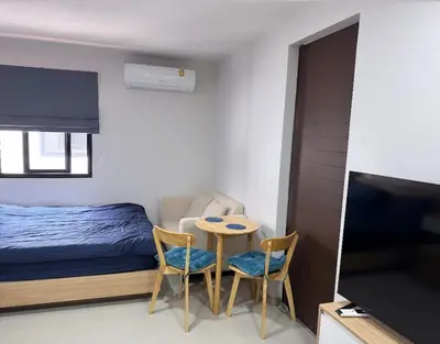 a bedroom with a bed and a table and chairs at Апартаменты VIP Great Hill Най - Янг in Nai Yang Beach
