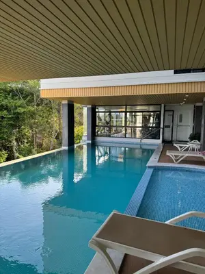 a swimming pool with a table and a building at Апартаменты VIP Great Hill Най - Янг in Nai Yang Beach