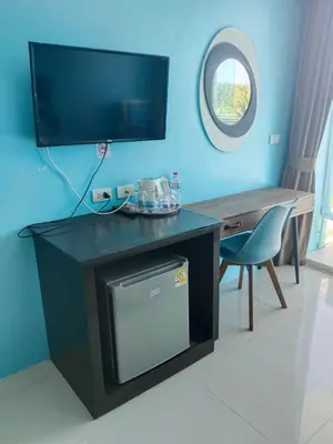 a living room with a tv and a desk with a chair at Bedroom301 Kata Beach Phuket in Kata Beach