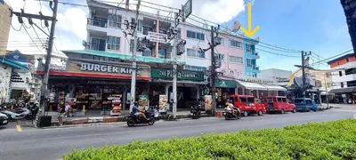 a busy city street with motorcycles driving past a building at Bedroom301 Kata Beach Phuket in Kata Beach