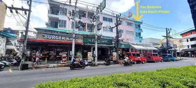 a busy city street with motorcycles driving past a building at Bedroom401 Kata Beach Phuket in Kata Beach