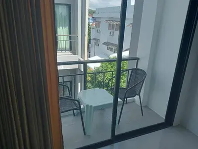 a balcony with two chairs and a table on it at Sawadee632,Naiharn&Rawai Beach Phuket in Phuket Town