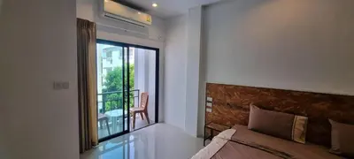 a bedroom with a bed and a balcony with a chair at Sawadee632,Naiharn&Rawai Beach Phuket in Phuket Town