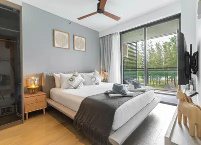 a bedroom with a bed and a large window at Serenity 2bd apartments in Cassia in Laguna Phuket