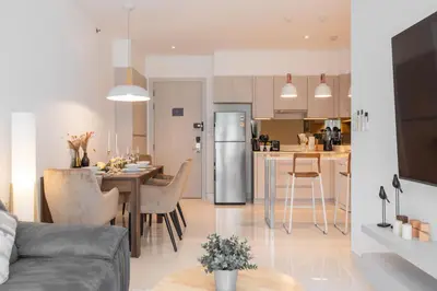 a kitchen and living room with a table and a refrigerator at Serenity 2bd apartments in Cassia in Laguna Phuket