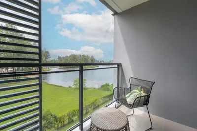 a balcony with a chair and a view of the water at Serenity 2bd apartments in Cassia in Laguna Phuket