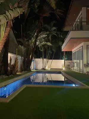 a swimming pool in front of a house at night at Euphoria Property in Kamala Beach