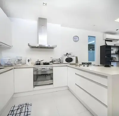 a white kitchen with white counters and appliances at Euphoria Property in Kamala Beach