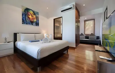 a bedroom with a large bed and a television at Euphoria Property in Kamala Beach
