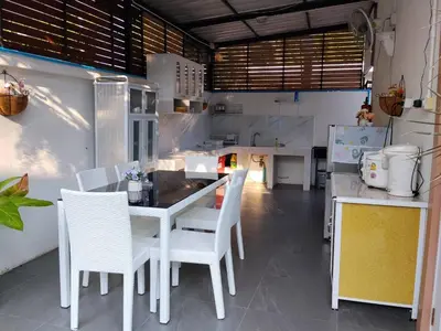 a kitchen with a table and white chairs in a kitchen at Cocoloco Pool Villa Ao Nang in Ao Nang
