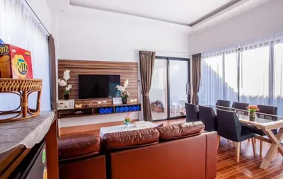 a living room with a couch and a table with chairs at Cocoloco Pool Villa Ao Nang in Ao Nang