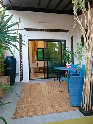 a living room with a table and some plants at Studio in Phuket Nai Harn in Rawai Beach