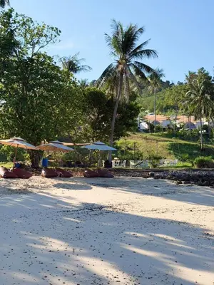 a beach with umbrellas and chairs on the sand at Seadome Kohyaoyai Resort & Restaurant