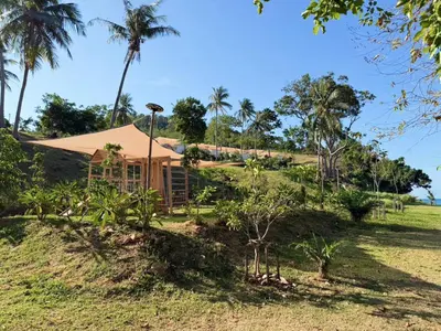 a house on a hill with palm trees at Seadome Kohyaoyai Resort & Restaurant