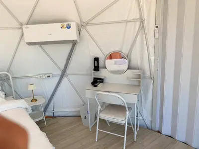 a bedroom with a desk in a tent at Seadome Kohyaoyai Resort & Restaurant
