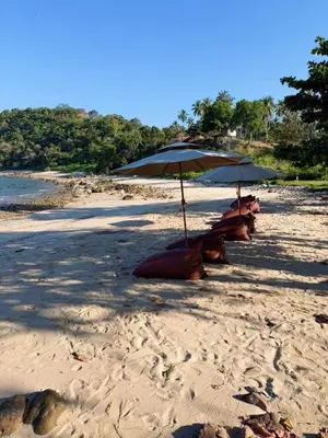 two umbrellas and chairs on a sandy beach at Seadome Kohyaoyai Resort & Restaurant